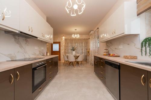 een keuken met roestvrijstalen apparatuur en een eetkamer bij Aurum Luxury Villa Voz by elite" in Laganas