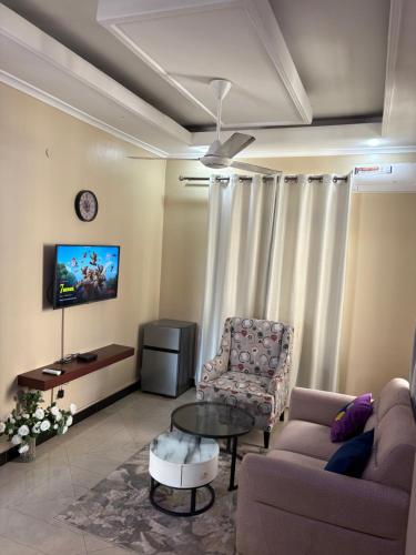 a living room with a couch and a table and a tv at Homelandheights in Dar es Salaam