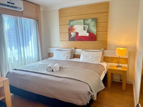 a bedroom with a large bed with two towels on it at H714- Congonhas Hotel Flat in São Paulo