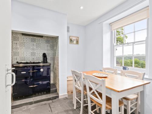 a kitchen with a wooden table and a stove at Croft Y Beudy in Henfynyw Upper