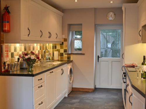 a kitchen with a sink and a dishwasher at The Granary in Carperby