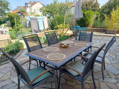 a wooden table and chairs on a patio at L'étoile du matin in Terville