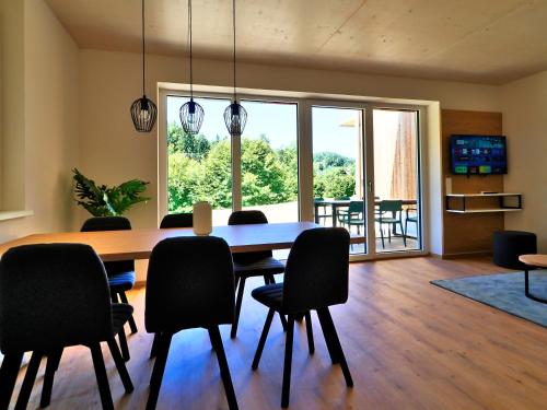 a dining room with a wooden table and chairs at OpenSky Wörthersee Lodge in Pörtschach am Wörthersee