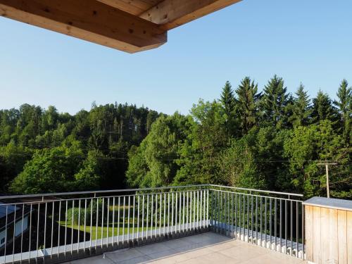 a balcony with a view of the woods at OpenSky Wörthersee Lodge in Pörtschach am Wörthersee