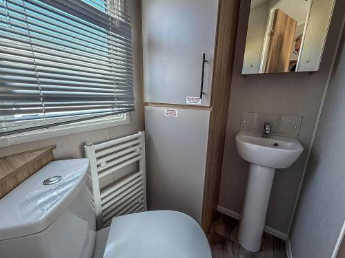 a small bathroom with a toilet and a sink at Beautiful 6 Berth Caravan, Nearby Beach In Suffolk Ref 68016Bs in Lowestoft