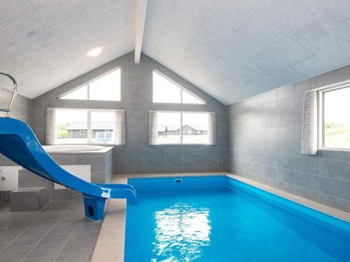 a swimming pool with a slide in a bathroom at Luxury Retreat in Mommark - By Traum Ferienwohnungen in Sarup