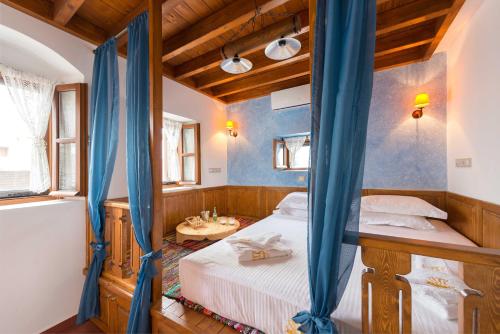 a bedroom with a bed with blue curtains at Villa Eftihia in Lindos in Líndos