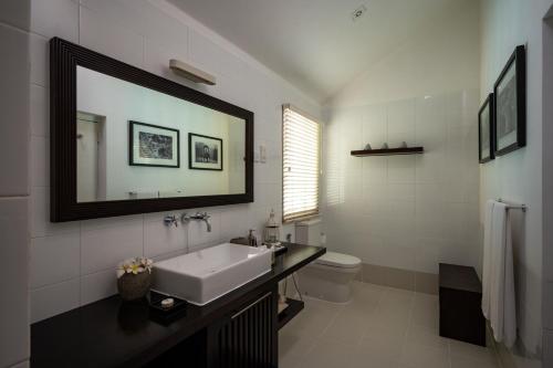 a bathroom with a sink and a toilet and a mirror at Nyne Hotels Rock Villa - Bentota in Bentota