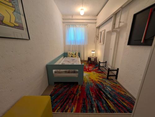 a room with a bed and a colorful carpet at Lovingly furnished apartment close to the lake in Zollikon