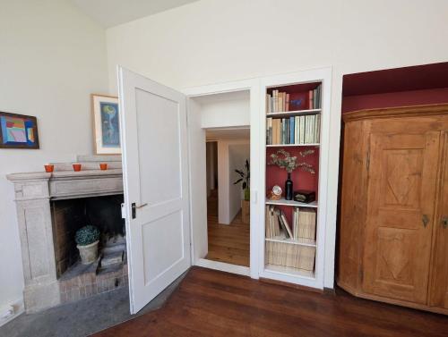 a room with an open door and a fireplace at Lovingly furnished apartment close to the lake in Zollikon