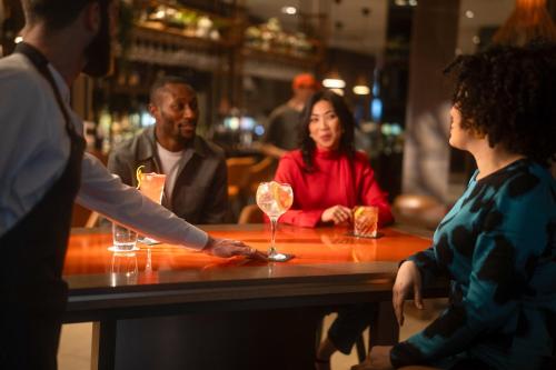 a group of people sitting at a table in a bar at Clayton Hotel, Manchester Airport in Hale