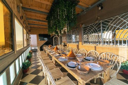 a long wooden table and chairs in a restaurant at Bella Vista Surf Camp in Tamraght Oufella
