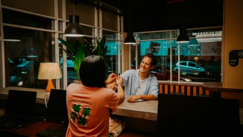 a woman cutting a mans hair in a barber shop at Viajero Casco Viejo Hostel in Panama City