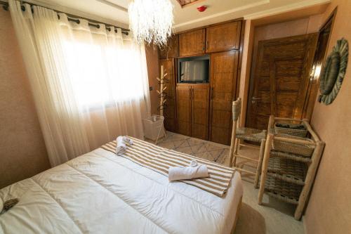 a bedroom with a bed and a chandelier at Bella Vista Surf Camp in Tamraght Oufella