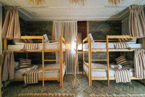 a room with three bunk beds in a room at Bella Vista Surf Camp in Tamraght Oufella