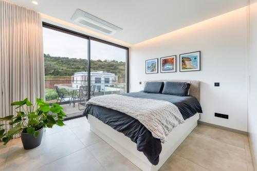 a bedroom with a bed and a large window at Villa Memorias by Algarve Holidays in Páteo