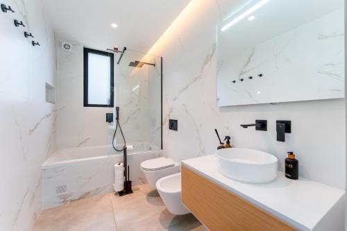 a white bathroom with a sink and a toilet at Villa Memorias by Algarve Holidays in Páteo