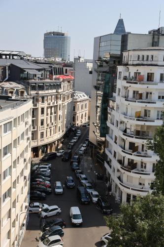 a city street with cars parked in a parking lot at Hotel Opera by Zeus International in Bucharest