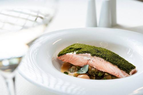 a bowl of food with a piece of meat in it at Sporthotel am Semmering in Semmering