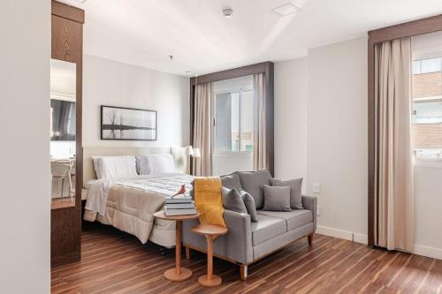 ein Schlafzimmer mit einem Bett, einem Sofa und einem Bett in der Unterkunft Flat prox. MASP e Av. Paulista - Limpeza Diária in São Paulo