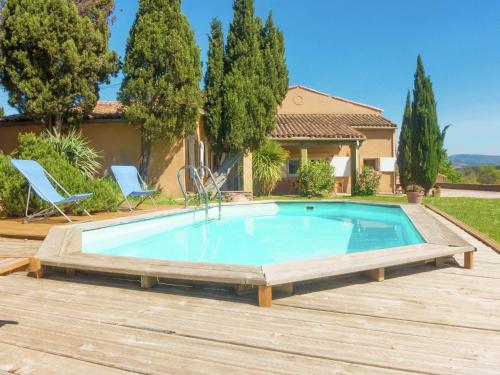 a swimming pool with a wooden deck and a house at Holiday Home in Loupia with Private Pool in Loupia
