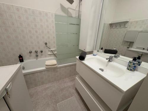 a white bathroom with a sink and a tub and a sink at Sunset Lakeview Small Paradise in Stresa