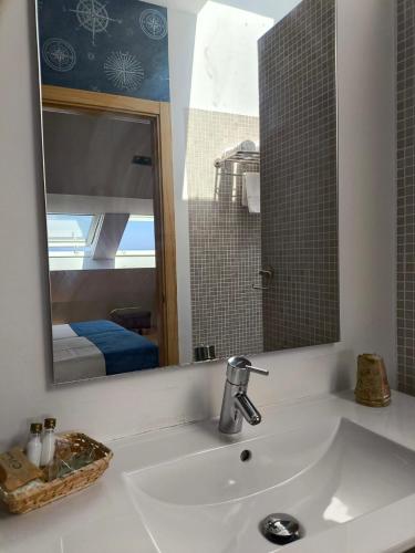 a bathroom with a sink and a mirror at Hotel O Noso Portosin in Portosin