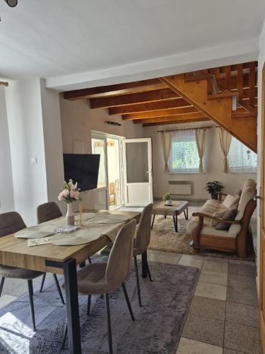 a living room with a large wooden table and chairs at Chata HUBERT in Liptovský Ján