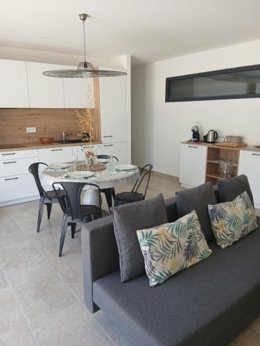a living room with a couch and a table at charmante maison neuve proche plage et commerces in Calvi