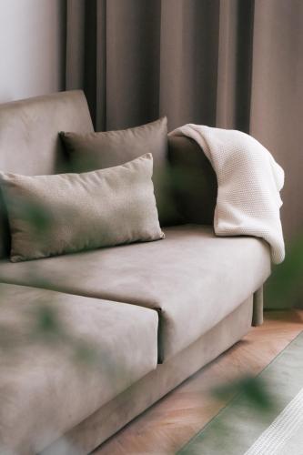 a couch with pillows on it in a living room at LOVIS Suites Vienna in Vienna