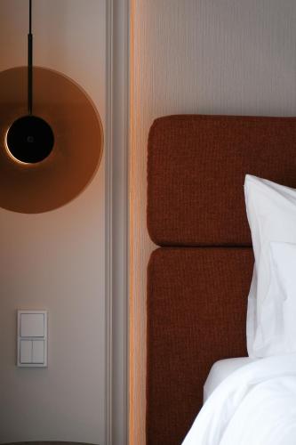 a bedroom with a bed with a brown head board at LOVIS Suites Vienna in Vienna