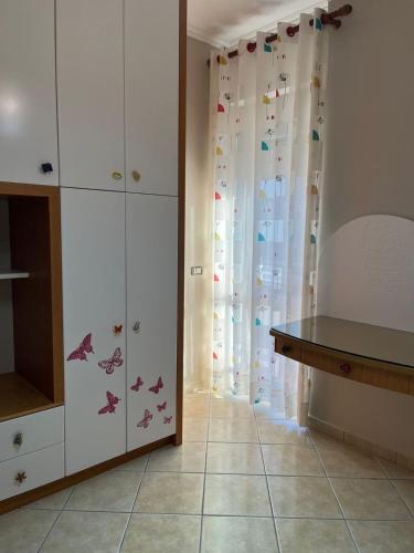 a kitchen with white cabinets with butterflies on them at Orikum Apartment in Orikum