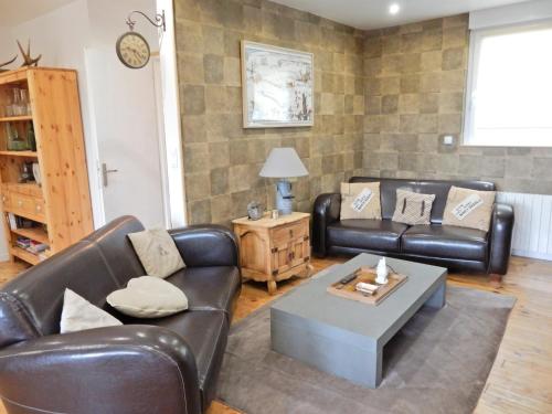 a living room with leather couches and a coffee table at Chalet in Raon-l'Étape near Lake in Raon-lʼÉtape