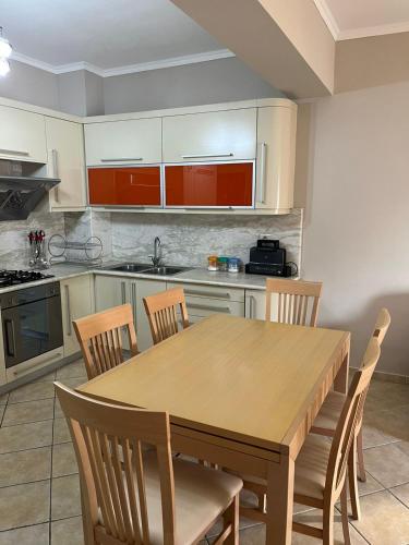 a kitchen with a wooden table and chairs at Orikum Apartment in Orikum