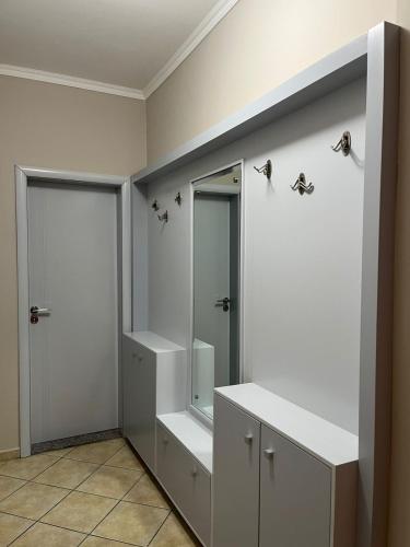 a bathroom with white cabinets and a mirror at Orikum Apartment in Orikum