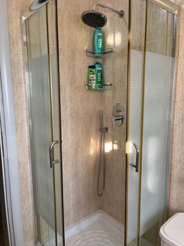a shower with a glass door and a toilet at Orikum Apartment in Orikum
