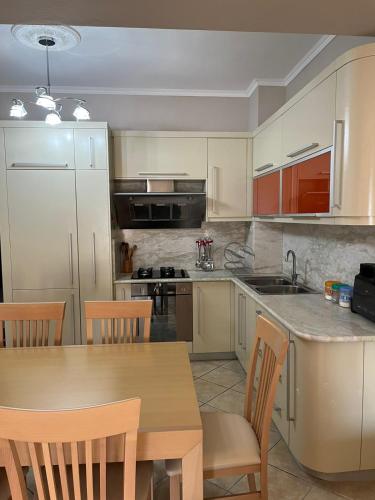 a kitchen with a wooden table and a table and chairs at Orikum Apartment in Orikum