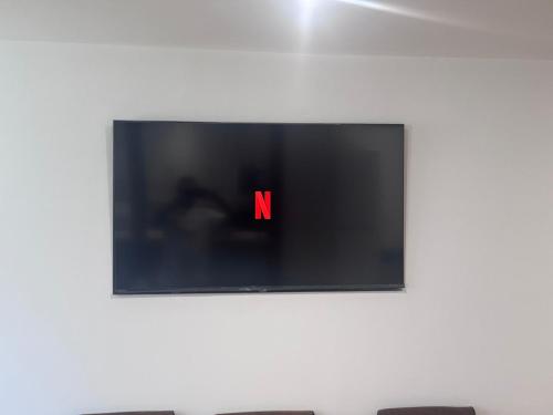 a television with a red letter on a wall at 4 Bedroom All En suite Central Townhouse Ideal for Groups in Builth Wells
