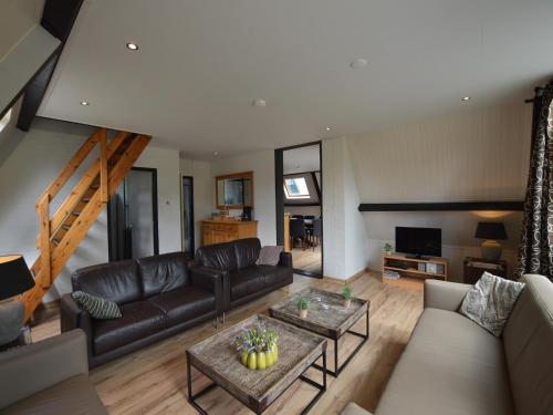 a living room with a couch and a table at Holiday Home in Stramproy Nature Reserve in Stramproy