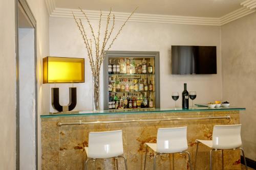 a bar with white chairs and a television at Hotel Buenos Aires in Rome
