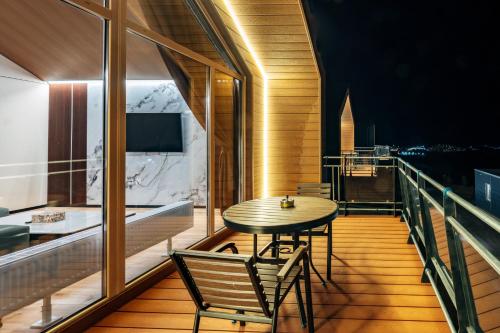 a room with a table and chairs on a balcony at Blue Spot Resort in Yoliin Hural