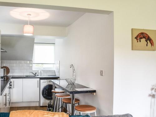 a kitchen with a table and some stools at Sheep's View Cottage in Eastbourne