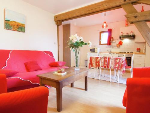 a living room with a red couch and a table at Cottage in Bourgnac with Whirlpool in Bourgnac