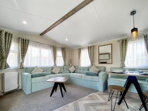 un salon avec un canapé bleu et une table dans l'établissement Brookwood, à Weston-super-Mare