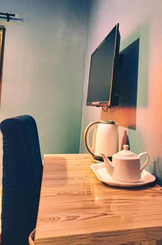 a table with a computer monitor and a tea pot on it at Prino Hotel And Suites 
