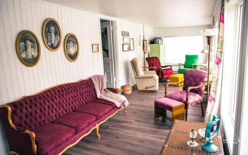 a living room with a purple couch and chairs at Spa & Pool Table - Le Parvis in Trois-Pistoles
