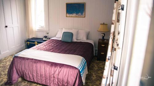 a bedroom with a bed with a blue laptop on it at Spa & Pool Table - Le Parvis in Trois-Pistoles