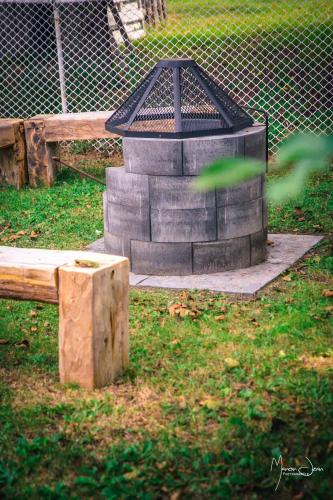 a large stone structure in the grass next to a bench at Spa & Pool Table - Le Parvis in Trois-Pistoles