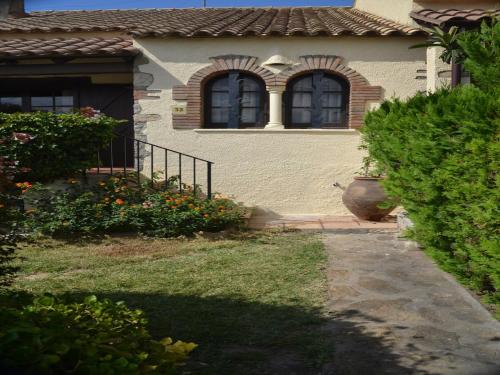 レスタルティットにあるHoliday Home in Torre Gran near Beachの窓2つと庭のある家