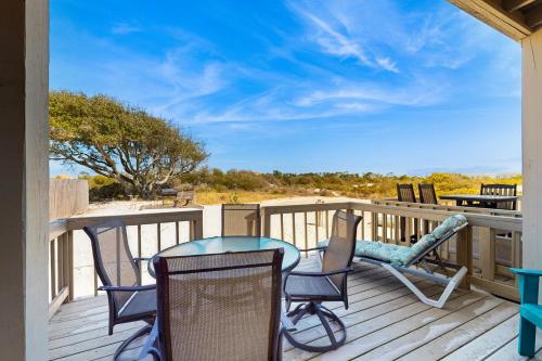 a patio with chairs and a table on a deck at North Lost Key Landing in Perdido Key